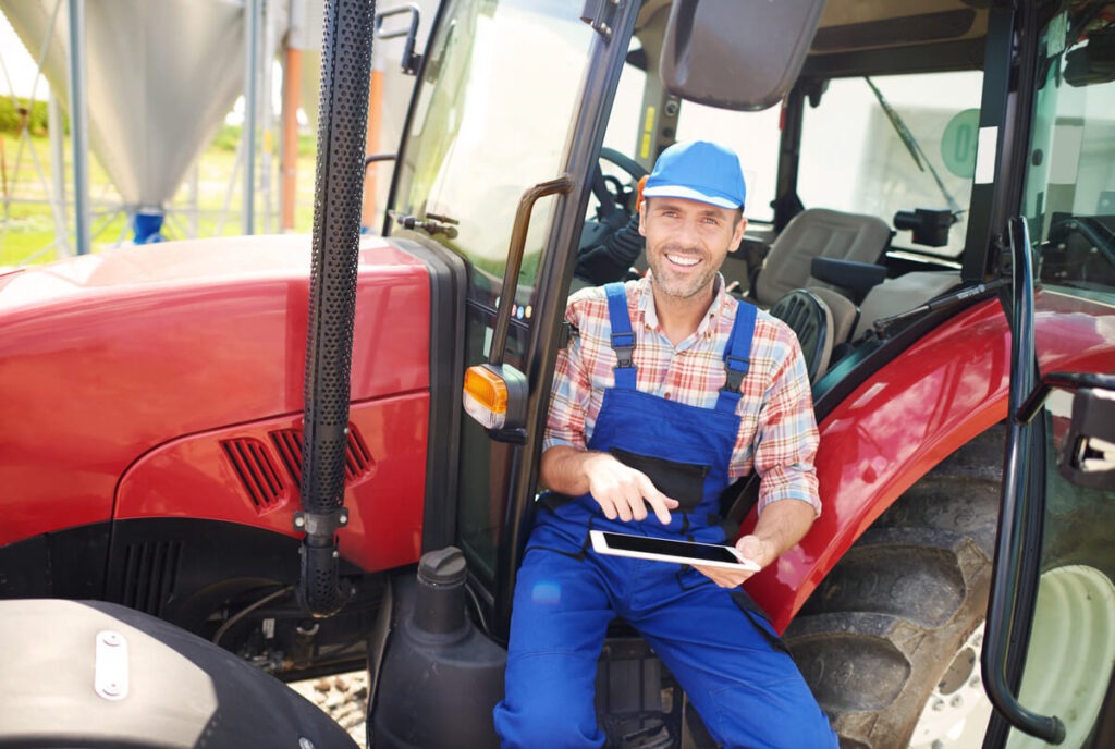 Agriculteur assis dans son tracteur avec une tablette tactile
